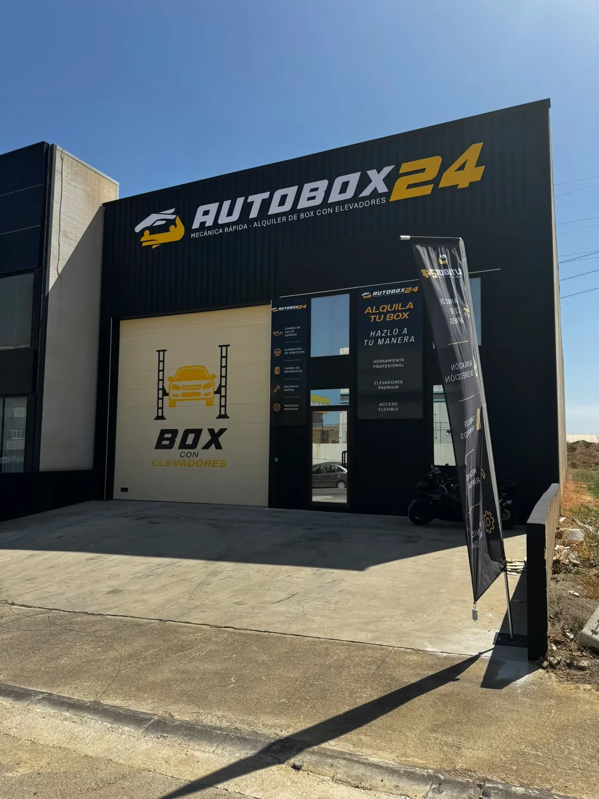 Vista lateral del local AUTOBOX 24 con el cartel Alquila tu box